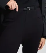 Pantalón negro de tiro alto, corte flare (acampanado) y tejido estructurado. Incluye un cinturón fino negro.