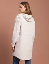 Gabardina impermeable color beige, marca Weatherproof, con cierre central, bolsillos delanteros con botones a presión, capucha desmontable y forro interno.