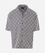 Camisa de manga corta Marfinno con corte boxy, cuello bowling y cierre frontal abotonado. Confeccionada en tejido texturizado con diseño geométrico de cuadros.