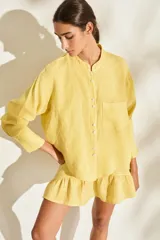 Camisa de lino italiano color beige, de corte holgado, con cuello mao, manga larga y bolsillo aplicado en el pecho.