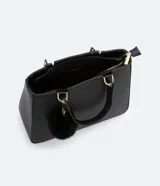 Bolso satchel negro con correa de mano fija y correa bandolera desmontable. Incluye llavero de pompón.