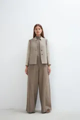 Chaqueta corta color marrón con cuello solapa y diseño con patchwork de telas. Manga larga con detalle de coderas aplicadas. Cierre frontal mediante botones y bolsillos ojal. Con forro.