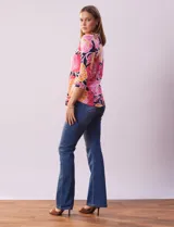 Remera de algodón estampada con flores en tonos celeste, azul y verde, sobre fondo negro. Tiene mangas 3/4 y escote cuadrado.
