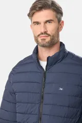 Campera de abrigo gris oscuro, capitoneada, con cuello alto y capucha desmontable. Cierre frontal con cremallera y bolsillos laterales con cierre. Logo bordado en el pecho.