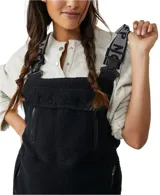 Mono de poliéster negro con textura de polar, tirantes ajustables con logo y hebilla, bolsillos delanteros y traseros con cierre.