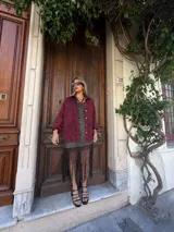 Camisa de denim color borgoña con efecto lavado, corte holgado, cuello clásico y cierre frontal con botones dorados.