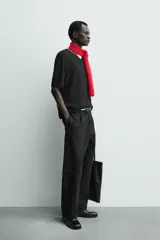 Pantalón de corte balloon fit y estilo relajado, confeccionado en tejido de algodón. Presenta pliegues frontales, cintura con trabillas, cierre frontal con cremallera y botón, bolsillos delanteros y bolsillos traseros de vivo.
