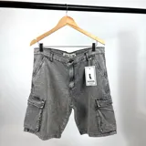 Bermuda de jean gris claro con lavado gastado y bolsillos cargo laterales.