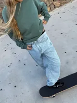 Pantalón de jean celeste con lavado ácido, corte amplio y tiro alto.