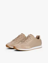 Zapatillas de corte bajo Tommy Hilfiger confeccionadas en piel napa color beige. Presentan paneles con mezcla de texturas, cordones tonales, suela de EVA blanca y detalle de contraste en el talón. Incluyen logo metálico de la marca en el lateral.