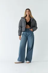 Campera puffer cropped color gris con capucha, cierre metálico y botones a presión.