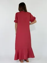 Vestido largo de lino color marrón tostado, con mangas 3/4 abullonadas, escote en V con volados y botones frontales. Cuenta con bolsillos laterales y detalle de volado en el dobladillo inferior.