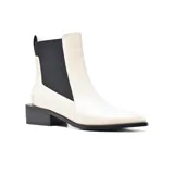 Botín Chelsea de charol negro con elástico lateral, punta fina y tacón cuadrado bajo.