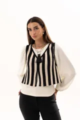 Chaleco tejido a rayas verticales en color negro y crudo, con escote en V y cierre frontal con ganchitos.