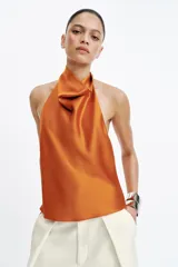 Top de cuello halter satinado en color naranja tostado, con espalda descubierta y cierre trasero de botones.