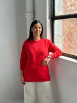Sweater de punto color rojo con diseño de rombos en relieve, cuello redondo y mangas largas con puños acanalados.