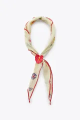 Bandana de algodón color crema con pequeños bordados multicolores y bordes con pespunte rojo a contraste. Incluye un accesorio ajustable en forma de flor roja metálica.