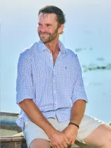 Camisa de vestir de hombre a cuadros celestes y blancos, de corte clásico, con cuello italiano y logo bordado en el frente.