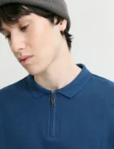 Remera de punto canalé francés con cuello polo, manga larga y cierre frontal de metal con tirador personalizado.