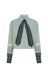 Camisa de algodón con estampado de rayas diagonales en tonos verdes y beige, corte recto y amplio. Presenta cuello clásico estructurado, mangas largas con puños anchos y cierre frontal de botones. Incluye una corbata a juego con rayas verticales en contraste.