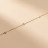 Pulsera de cadena fina en oro 18k con engarces de circonias distribuidas a lo largo de la pieza.