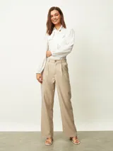 Pantalón de vestir beige de corte recto y tiro alto, con pinzas frontales y trabillas para cinturón.