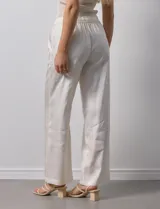 Pantalón palazzo color crudo de lyocell marca Nanette, con pretina elastizada, lazo de ajuste y bolsillos delanteros.