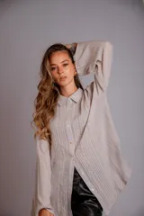 Camisa blanca de manga larga con detalle de bordados verticales en el frente y puños acampanados.