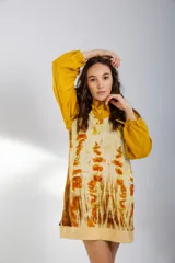 Chaleco de lana merino color crema, con escote en V y diseño sin mangas. Se usa sobre una camisa mostaza de mangas largas con puños elásticos.