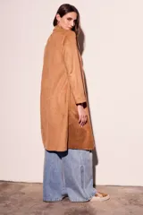 Trench largo color beige de gamuza sintética, con solapas y corte recto.