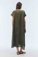 Vestido midi evasé color azul, confeccionado en lino, con escote redondo, mangas cortas con dobladillo vuelto y bolsillos laterales. Presenta un ruedo asimétrico, más largo en los laterales.