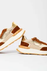 Zapatillas deportivas con base blanca y detalles en marrón, rosa y amarillo.