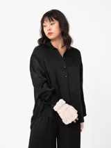 Camisa color ladrillo de corte amplio y mangas largas, con cuello camisero y cierre frontal con botones.