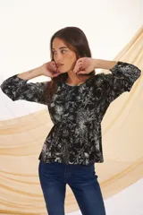 Blusa de manga larga con estampado floral en tonos verde y blanco.