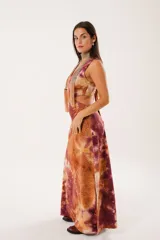 Vestido largo con estampado batik en tonos marrones y borgoña, escote en V, sin mangas y abertura lateral.
