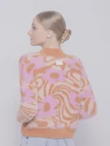 Sweater de punto color naranja y rosa con diseño de jacquard, textura peludita, manga larga y cuello alto.