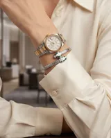 Esclava rígida de acero con diseño de serpiente, decorada con esmalte blanco y detalles en verde en la cabeza.