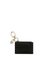 Estuche para tarjetas color negro de diseño compacto con ranuras externas para tarjetas, compartimento superior con cremallera y herrajes metálicos dorados que incluyen un llavero integrado.
