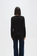 Remera de manga larga con cuello a la base, confeccionada en tejido de punto canalé con diseño holgado.
