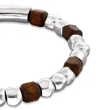 Pulsera elástica con cuentas de aleación de metales bañadas en plata y cuentas de madera.