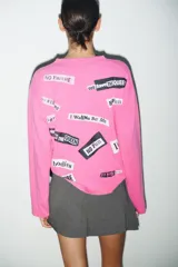 Remera de manga larga y cuello redondo en color fucsia, con estampa frontal de la banda Sex Pistols en contraste.