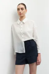 Short de tiro alto color azul marino, confeccionado en tejido tweed, con dos bolsillos frontales y cintura elástica.