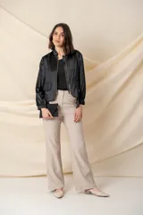 Campera negra con cierre metálico y bolsillos con hebillas doradas.