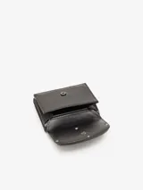 Billetera compacta de tres pliegues confeccionada en cuero vacuno con acabado espejado. Presenta un diseño minimalista en color negro con el logo ovalado de la marca en relieve al tono en la parte frontal. Incluye ranuras para tarjetas, compartimento para billetes y bolsillo para monedas.
