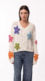 Sweater de punto grueso color crudo, con escote en V y calce relajado. Presenta flores tejidas en relieve de diversos colores aplicadas en el frente y las mangas.