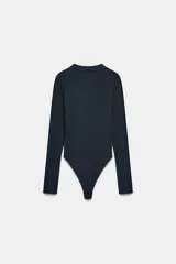 Body de manga larga con cuello redondo, confeccionado en una mezcla de algodón y modal. Presenta cierre inferior con botones a presión.
