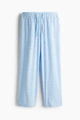 Pantalón de franela de algodón suave, color celeste con estampado a cuadros blancos. Tiene cintura elástica con cordón ajustable y bolsillos al bies. Corte relajado.
