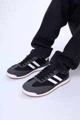 Championes urbanos de diseño retro, combinan paneles de gamuza gris en la puntera y talón con cuerpo de material sintético negro. Presentan dos franjas laterales blancas, cordones negros y suela de goma con base color caramelo.