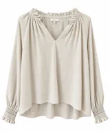 Blusa de lino color beige, de corte holgado, con escote en V y cuello fruncido con volados. Mangas largas abullonadas con puños elásticos fruncidos.