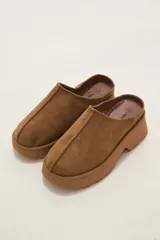Zueco tipo mule de gamuza color camel, con plataforma de goma al tono y costura central decorativa.
